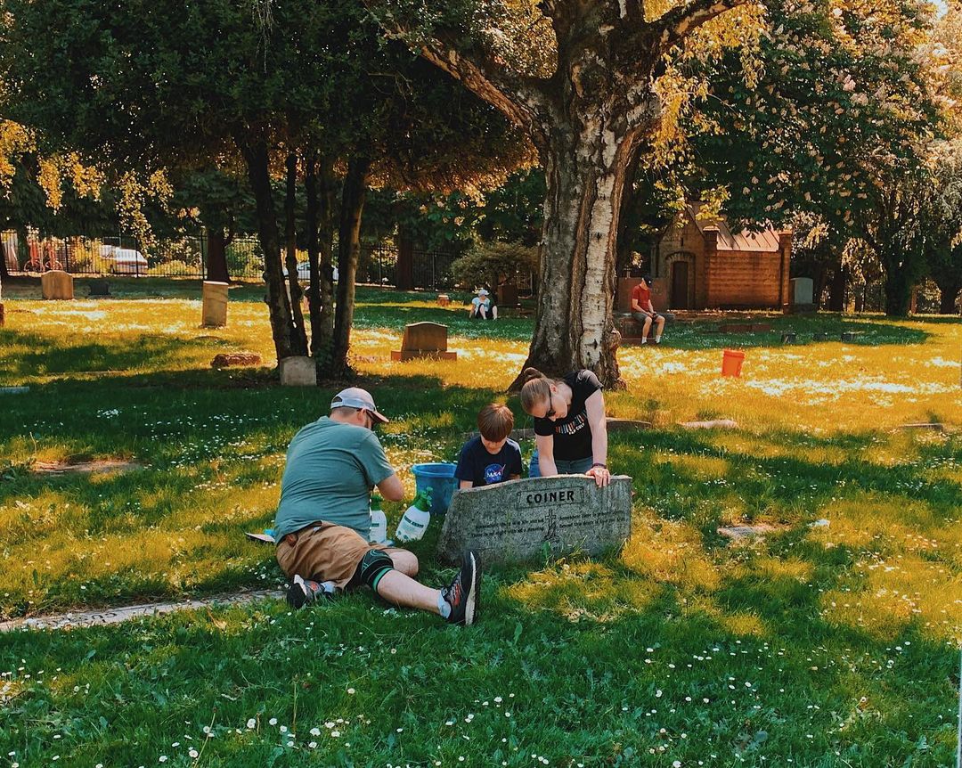 a family cleaning tombstones